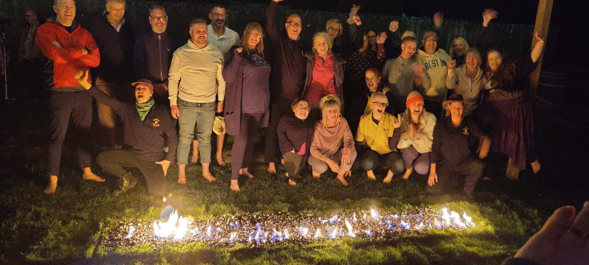 Image shows the jubilant Firewalkers with the hot coals in front of them